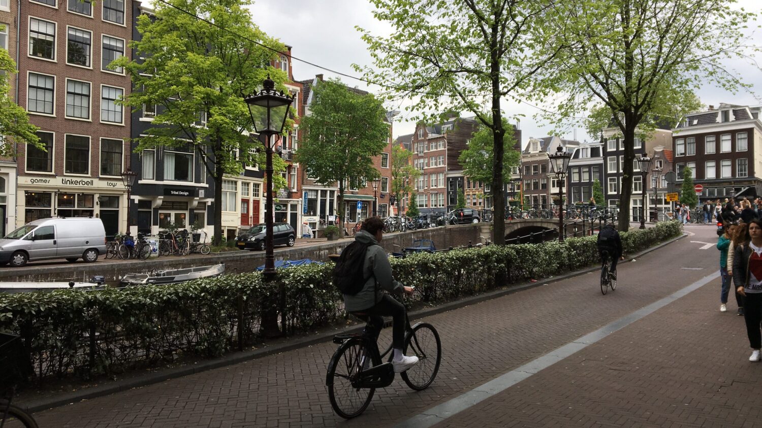 Cycling along a picturesque canal street in Amsterdam