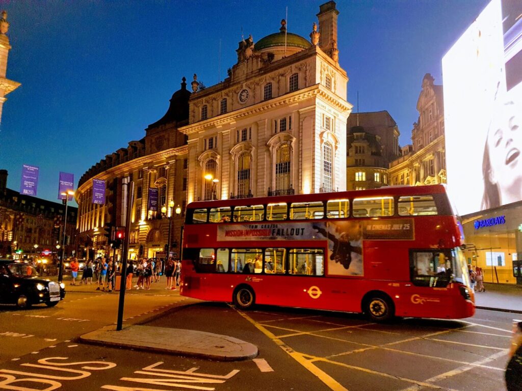 Picture of Piccadilly Circus at night featuring with buses, billboards